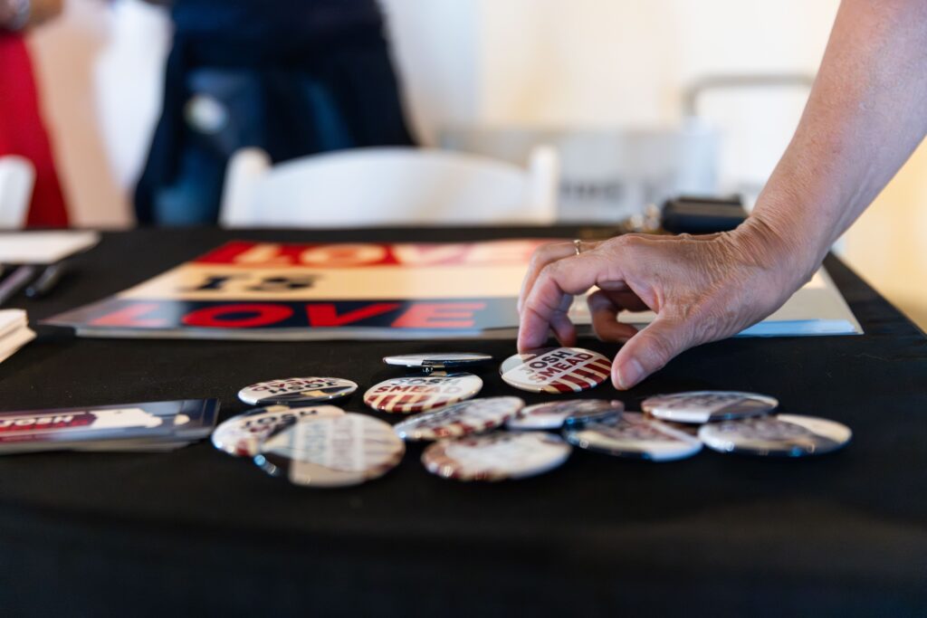 Photo of table with merchandise including buttons and signs. 